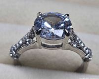 Profile view of ring displaying center stone and shoulder accents