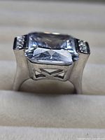 Front view of ring showing square clear centerpiece and side stones