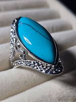 Oblique view of ring showing marquise turquoise cabochon and side filigree