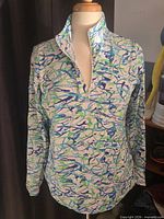 Front view of IBKUL quarter-zip shirt on mannequin