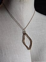 Full view of necklace on mannequin tors showing chain length and pendant drop