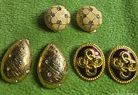 All three pairs of earrings on green background