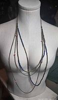 Full view of necklace on mannequin showing layered strands