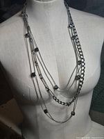 Full view of necklace on form showing length and multiple strands
