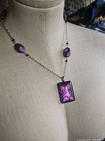 Full view of necklace on mannequin showing chain, beads, and pendant