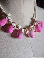 Full view of necklace on bust showing pink dyed shell drops and off-white spacer beads