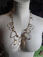 Full view of gold tone wire loop necklace on mannequin