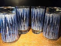 Four glasses displayed, two upright two inverted showing pattern and bases