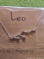 Front view of necklace on backing card showing Leo pendant and chain