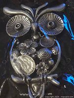 Front view of silver-tone owl brooch in packaging