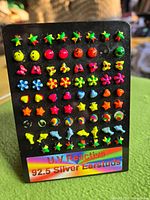 front view of black display card showing multiple neon stud earrings