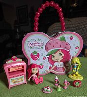 Group shot showing lunch box, oven, two dolls, cupcakes and plate