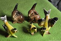 Group view of two rabbits and three birds on green surface