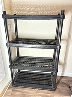 Full view of 4-tier black plastic shelving unit