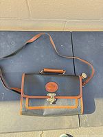 Full view of the Dooney & Bourke black pebbled leather satchel with strap