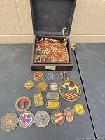 Open wooden box with fabric lining and assortment of coins displayed