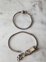 Both bracelets laid flat to show overall form and chain type