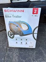 Front of retail box showing Schwinn Shuttle 2-seat bike trailer image and specs