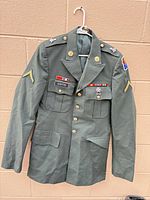 Full view of jacket front on hanger showing insignia and ribbons