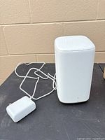 Front/side view of white gateway with power adapter