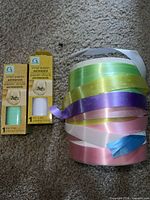 two boxed vinyl paper rolls and stacked ribbon rolls