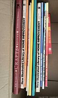 Stack of Victorian Crafts Revived and eight New Illustrated Library of Home Improvement magazines inside box
