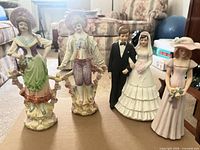 Group view of all five figurines standing on table