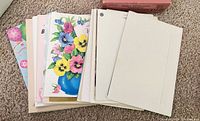 Stack of assorted greeting cards showing floral and balloon designs