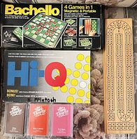 Overall lot view showing all boxed games, cribbage board and card decks
