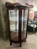 Front view of curved glass mahogany cabinet showing doors and shelves