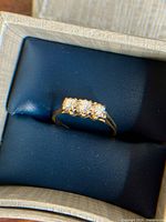 18kt gold ring with three diamonds displayed in box