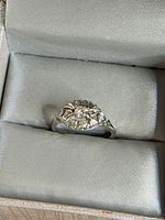 Ring in box close-up showing diamond cluster and gold colour