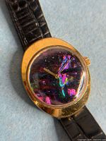 Front view of watch showing abalone dial and gold case