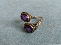 Ring angled view showing both amethyst stones and silver detailing