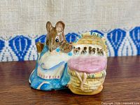 Front view of Beswick Hunca Munca with cradle figurine