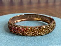 Full view of gemstone-set top of bangle showing colour gradient