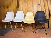Group shot of four Eames-style chairs showing colors and bases