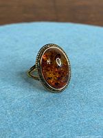 Three-quarter view of amber ring on fabric