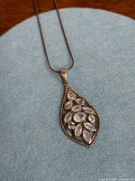 Front view of pendant on chain showing moonstones and design