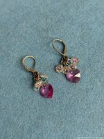 both earrings on blue background, showing heart crystals and fringe beads