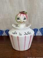 Full view of jar with lid displaying design and text