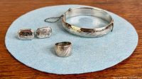 All four sterling silver pieces arranged on blue felt
