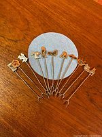 All eight alpaca cocktail forks fanned out on surface