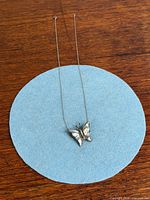 Full necklace laid out showing chain length and butterfly pendant