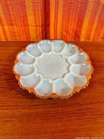 Top view showing 12 egg wells, central dip area, scalloped gold-trimmed edge