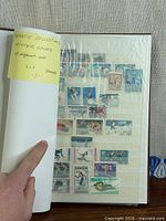 Album cover opened showing sticky note indicating 360 winter sports stamps