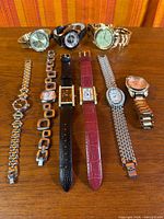 All nine watches laid out showing variety of styles, bands and case shapes