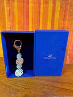 Keychain displayed upright in open blue Swarovski box