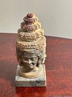 Front-left view of soapstone four-faced deity statue on marble base