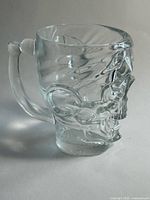 Front view of clear glass skull mug with handle
